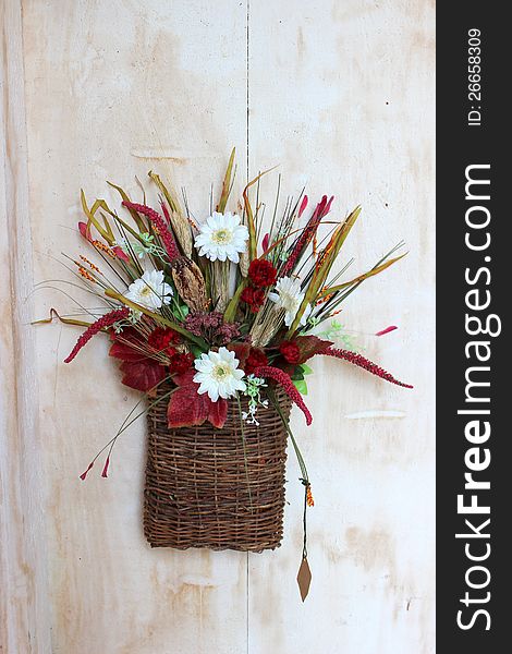 Colorful fall arrangement with flowers and foliage placed together in a woven twig basket. Colorful fall arrangement with flowers and foliage placed together in a woven twig basket.