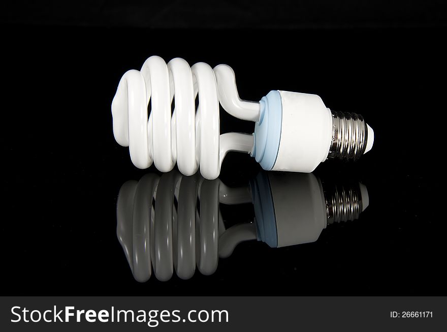 Picture of a fluorescent light bulb on a black reflective surface