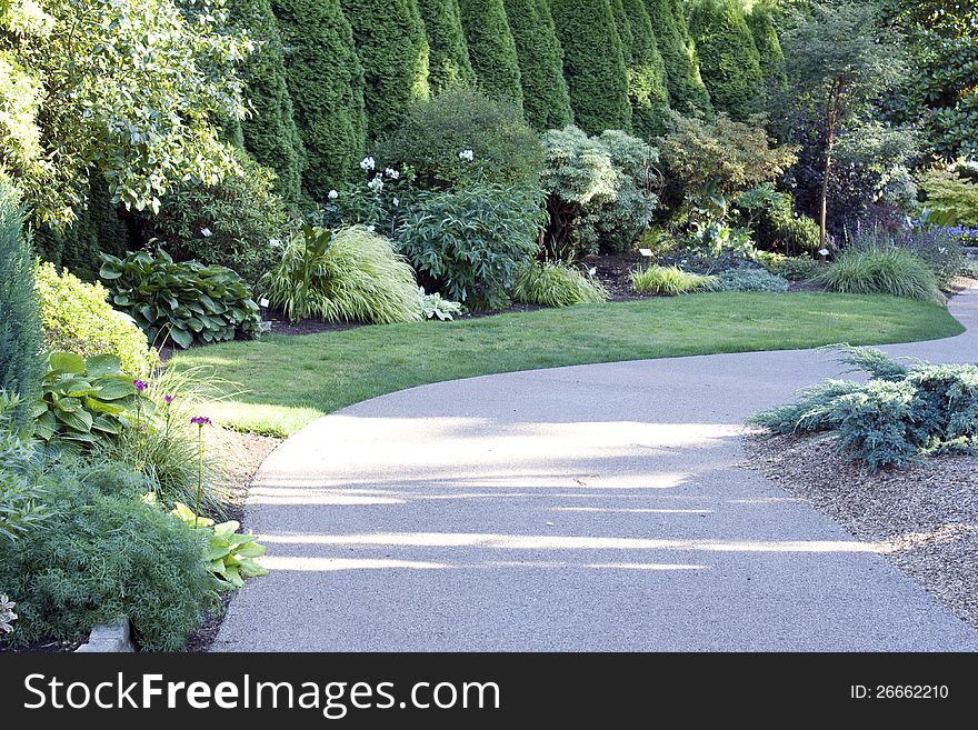 A garden path with lots of flowers and interesting shape.