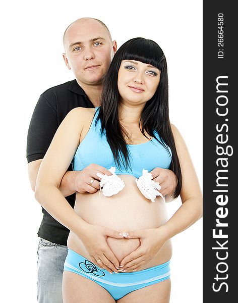 Happy pregnant couple with baby shoes
