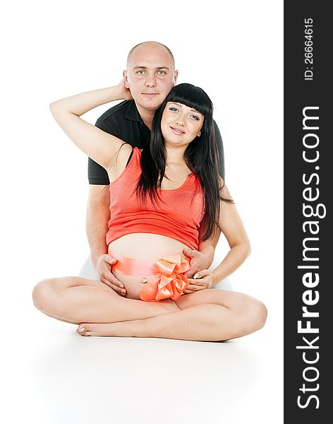 Happy pregnant couple with a bow on her stomach