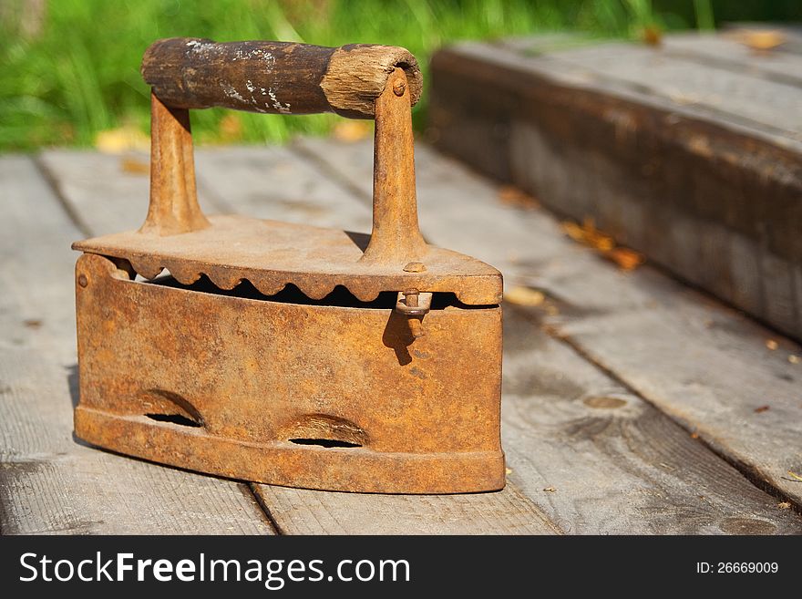 Old coal iron, standing on a wooden sidewalk. Old coal iron, standing on a wooden sidewalk