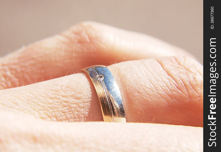 White and yellow gold ring, with a diamond, on male finger