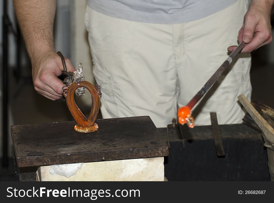 A hot glass drop being turned into a glass decoration in a small glass factory in Prague, Czech Republic