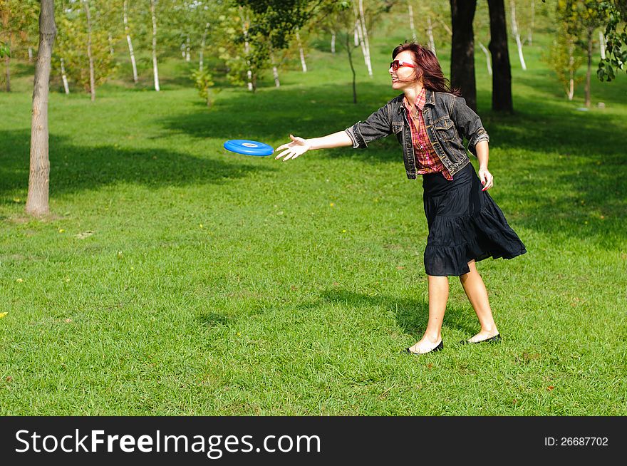 Young woman having fun with frisbee in the parkin sunny summer day. Young woman having fun with frisbee in the parkin sunny summer day.