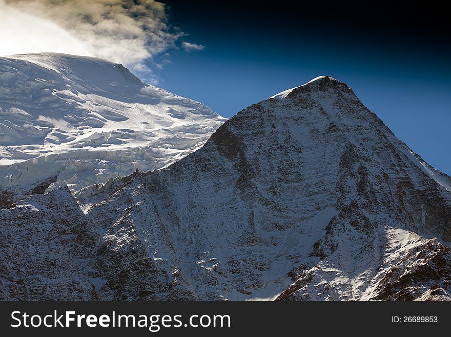 Snow Covered Mountains And Rocky Peaks In The Alps