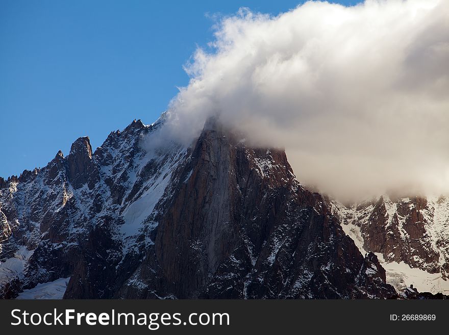 Snow covered mountains and rocky peaks in the French Alps in the Mont Blanc Massif. Snow covered mountains and rocky peaks in the French Alps in the Mont Blanc Massif