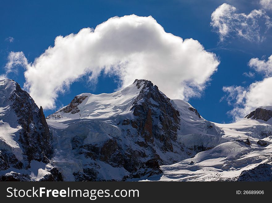 Snow Covered Mountains And Rocky Peaks In The Alps