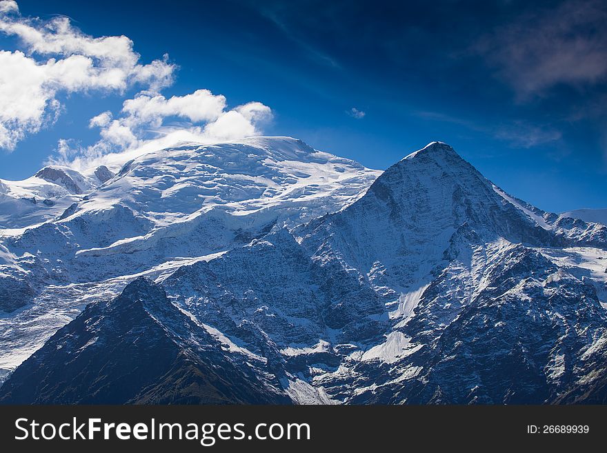 Snow covered mountains and rocky peaks in the French Alps in the Mont Blanc Massif. Snow covered mountains and rocky peaks in the French Alps in the Mont Blanc Massif