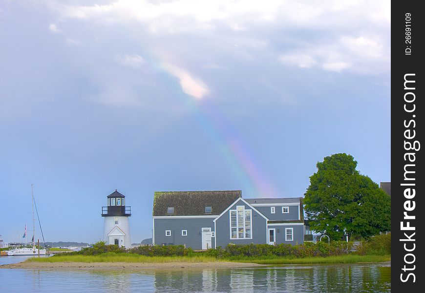 The rainbow shines over a house after a rain shower. The rainbow shines over a house after a rain shower.