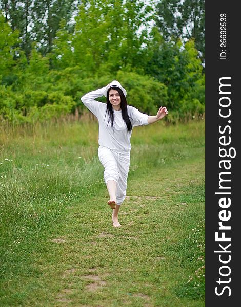A young woman joyously jumping and running in a summer setting. A young woman joyously jumping and running in a summer setting