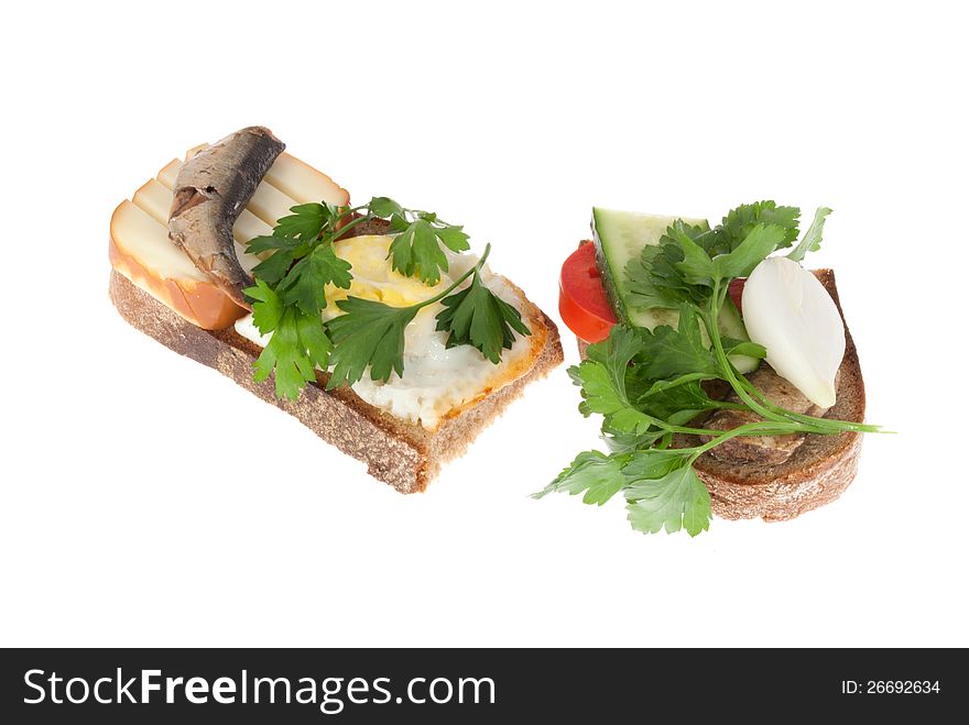 Two bits rye-bread with canned fish, egg and cheese. Isolated on a white background.