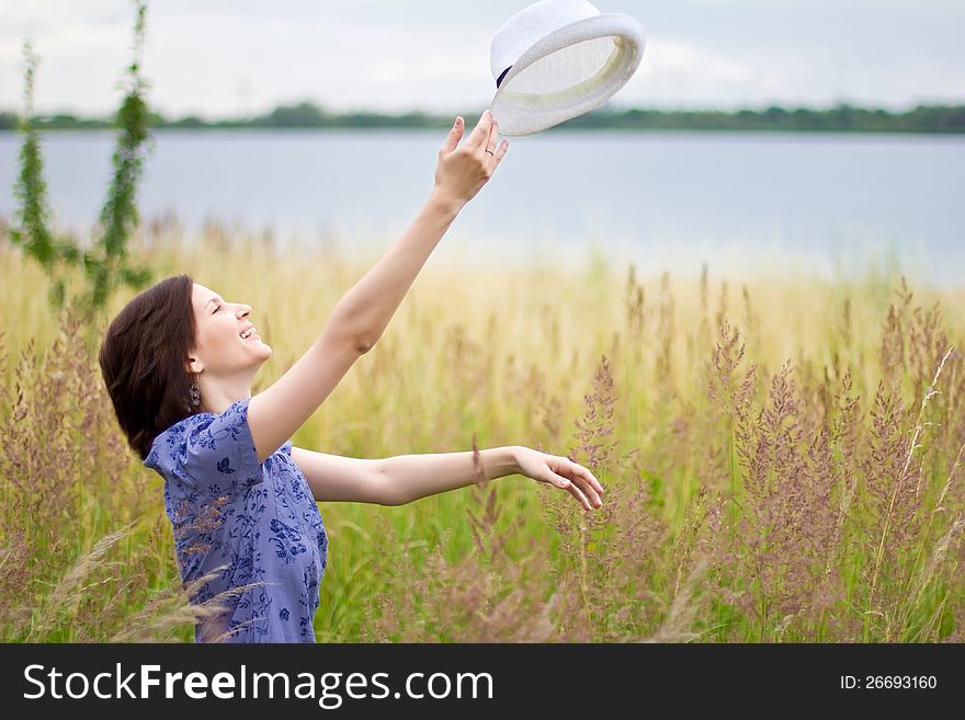 Young happy woman throwing up the straw hat. Young happy woman throwing up the straw hat