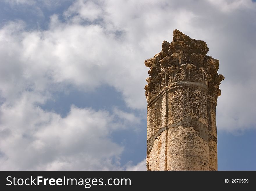 A high harmonous column in ancient port Caesaria on a background of the cloudy sky. A high harmonous column in ancient port Caesaria on a background of the cloudy sky