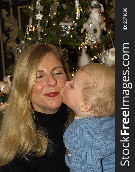 A Child kissing his Mother at Christmas. A Child kissing his Mother at Christmas