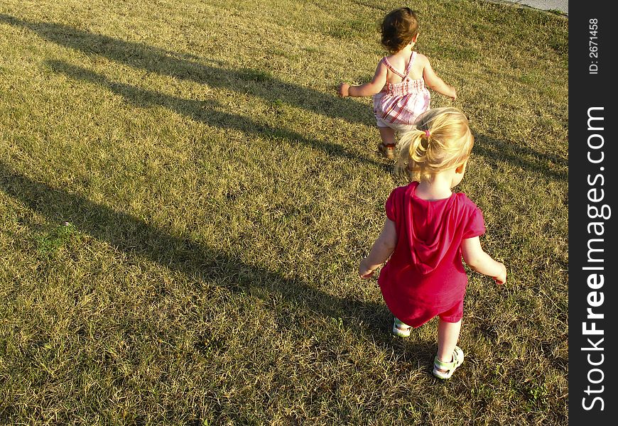 Two small baby girl run in the park. Two small baby girl run in the park