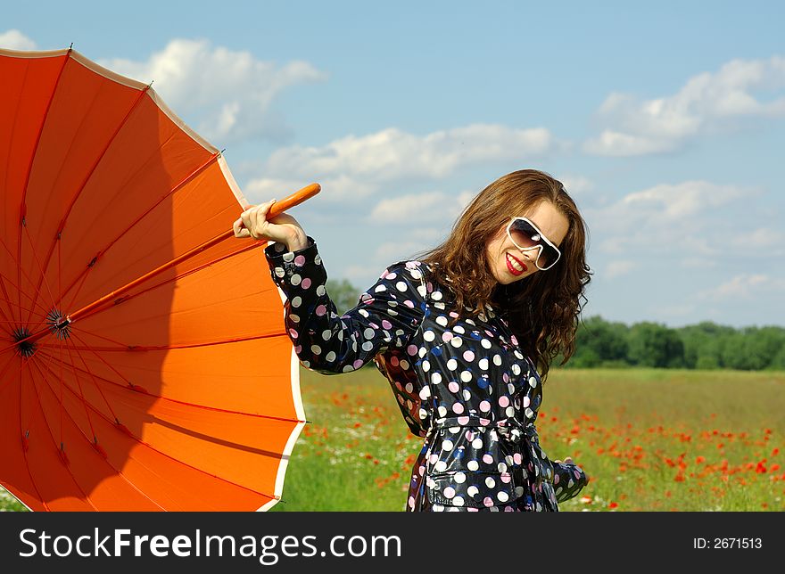 Happy young brunette with orange umbrella