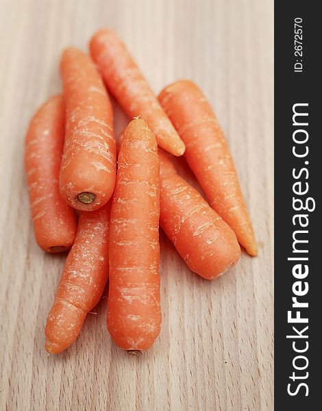 Uncooked baby carrots on a chopping board