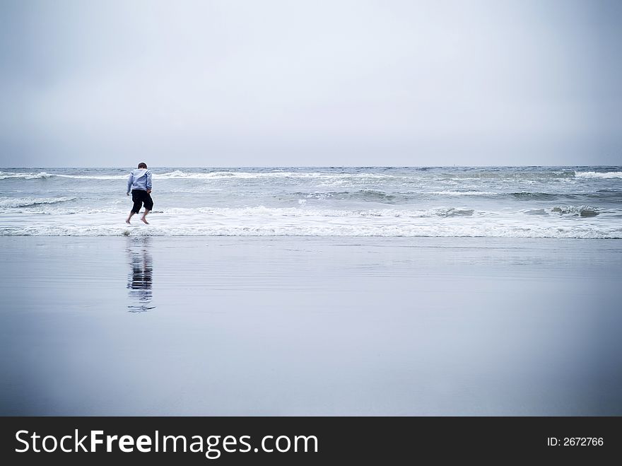 Boy jumping over wave at beach in California. Boy jumping over wave at beach in California