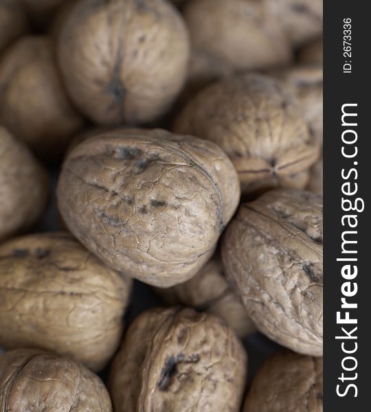 Close up of a pile of walnuts in the shells