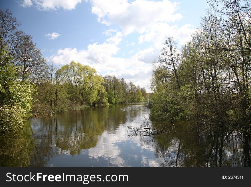 Channel landscape with clouds in spring