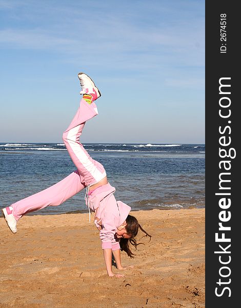 Girl on beach doing a handstand