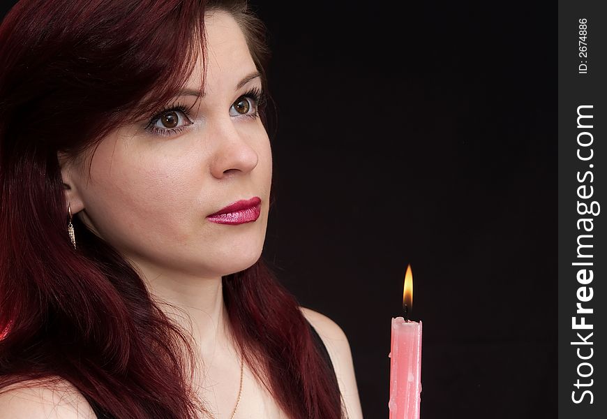 Girl and burning red candle. Girl and burning red candle