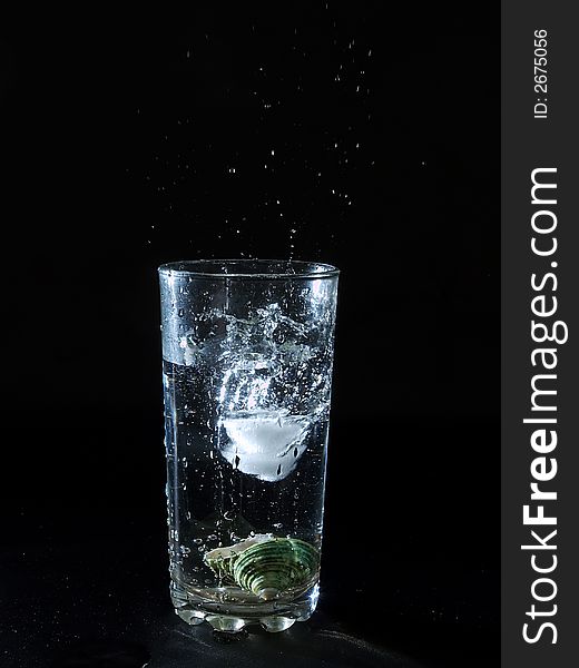 Ice splashing water in the glass