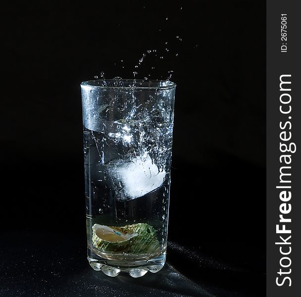 Ice splashing water in the glass