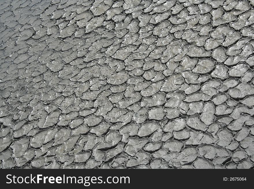 Grey mud texture with cracks and a little water