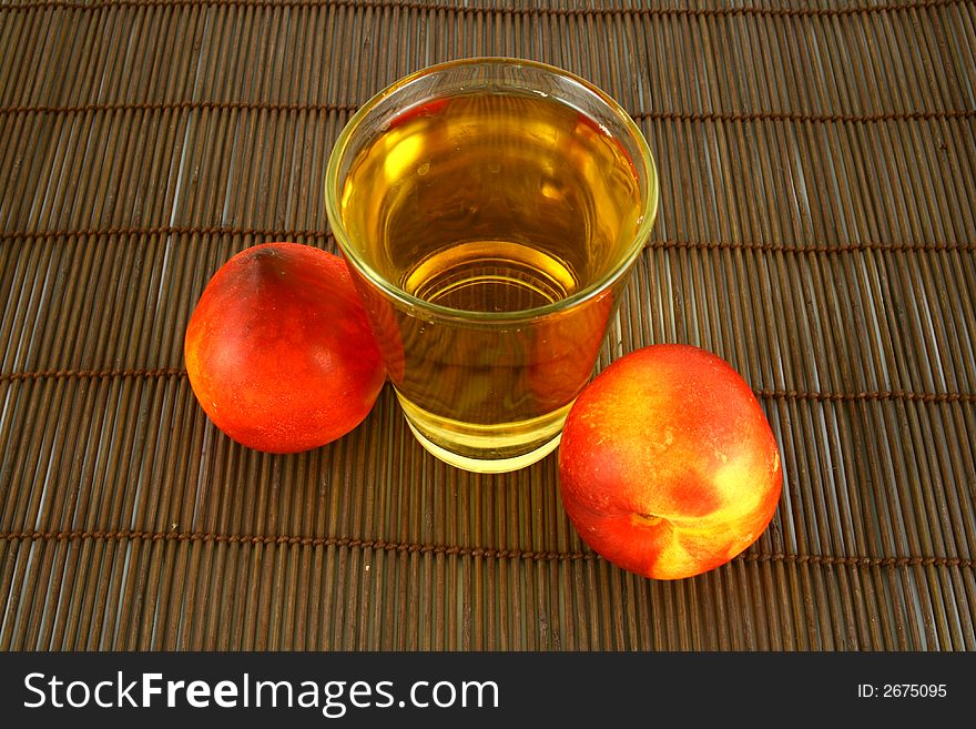 Glass of icetea and nectarine fruit - close-up. Glass of icetea and nectarine fruit - close-up