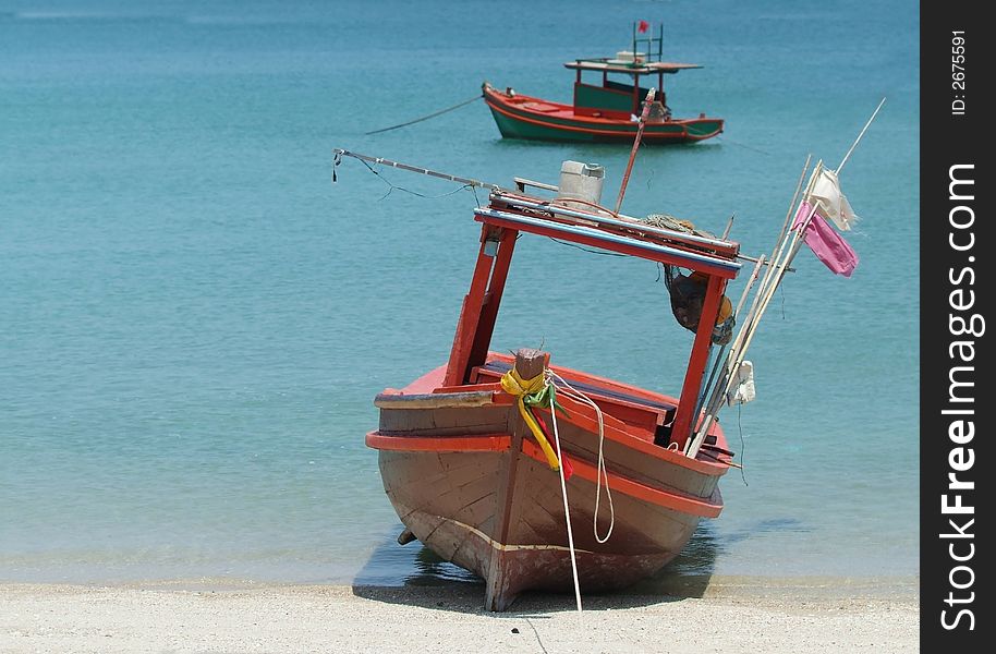 Two small, wooden fishing boats at a beach in Thailand. Two small, wooden fishing boats at a beach in Thailand