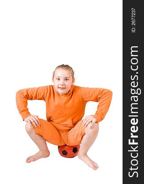 A pretty young girl sitting on a football