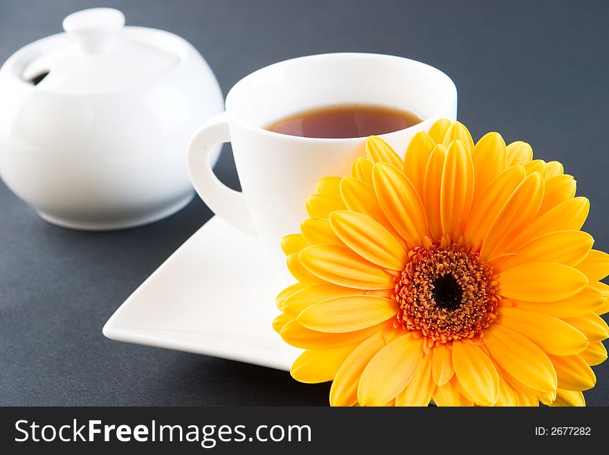 A cup of tea with a gerbera daisy