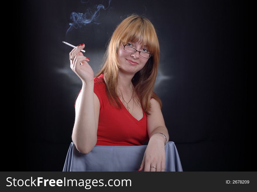 Girl smoking a cigarette on a dark background. Girl smoking a cigarette on a dark background