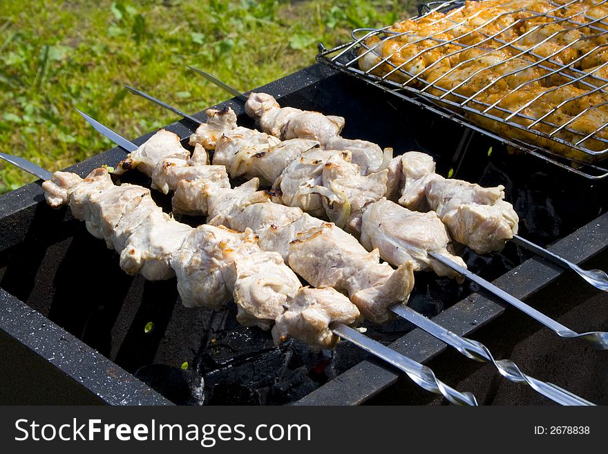 Appetizing shish kebab on the grill with metal skewers. Appetizing shish kebab on the grill with metal skewers