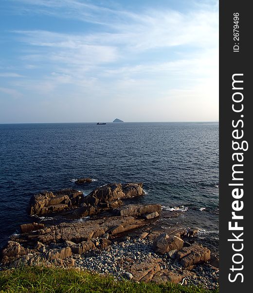 Ocean landscape with rock coast and ship at the horizon. Ocean landscape with rock coast and ship at the horizon