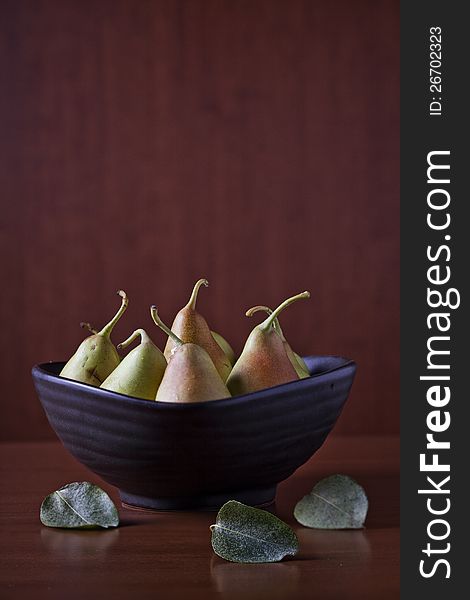 Photograph of a few tiny pears in a bowl