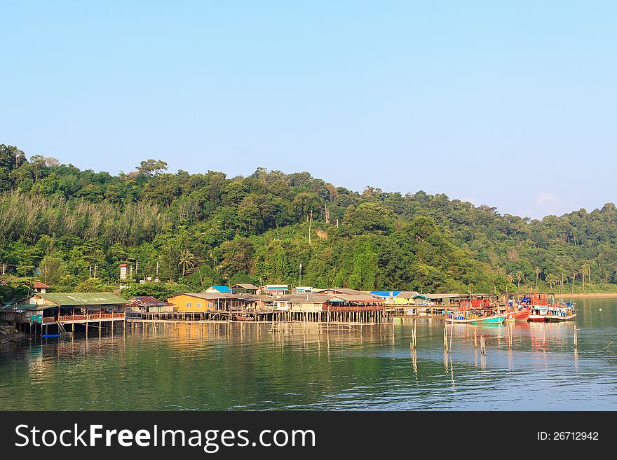 Boathouse, houses on stilts, sea and green hills. Koh Chang, Thailand. Boathouse, houses on stilts, sea and green hills. Koh Chang, Thailand.