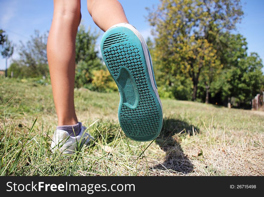 A young girl enjoys running on the green grass. A young girl enjoys running on the green grass