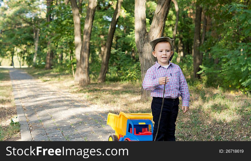 Little Boy Pulling A Toy Truck