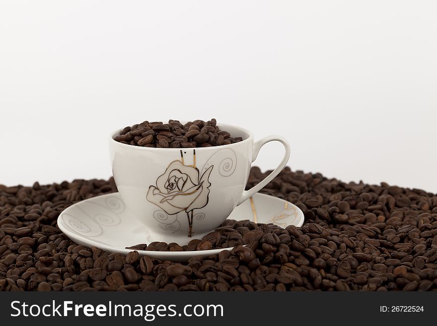 Coffee beans in cup on white background