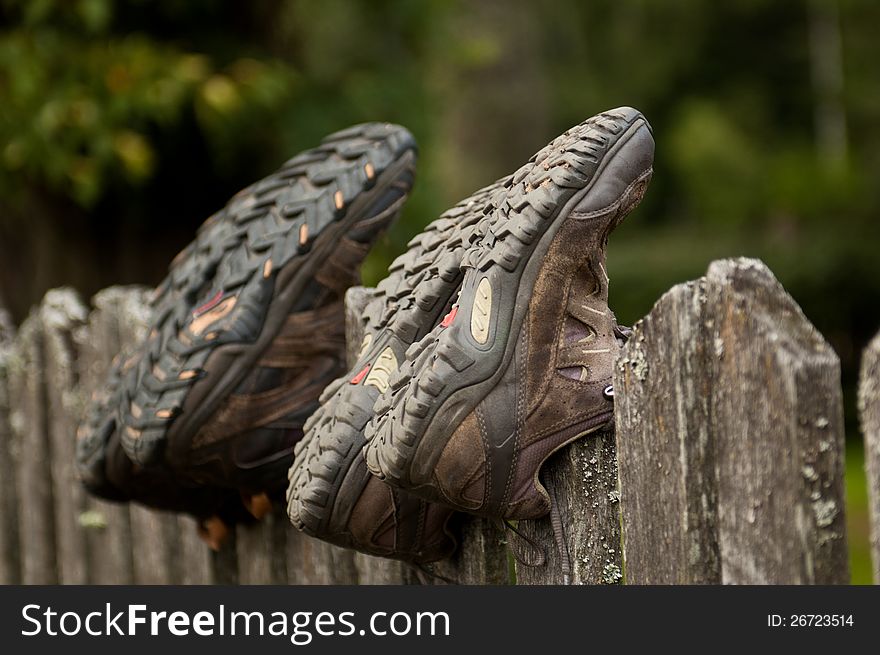 Hiking shoes on a wooden fence. Hiking shoes on a wooden fence