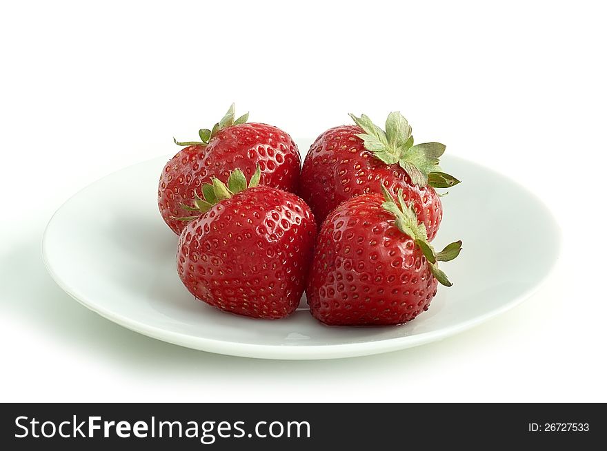 Four strawberries on a white saucer with white background