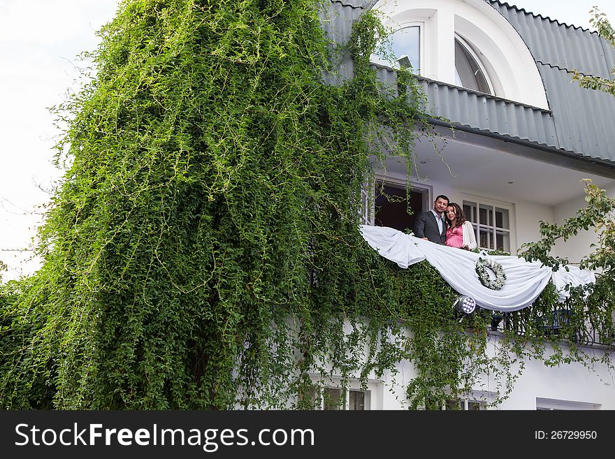 Young couple on balcony of his new home