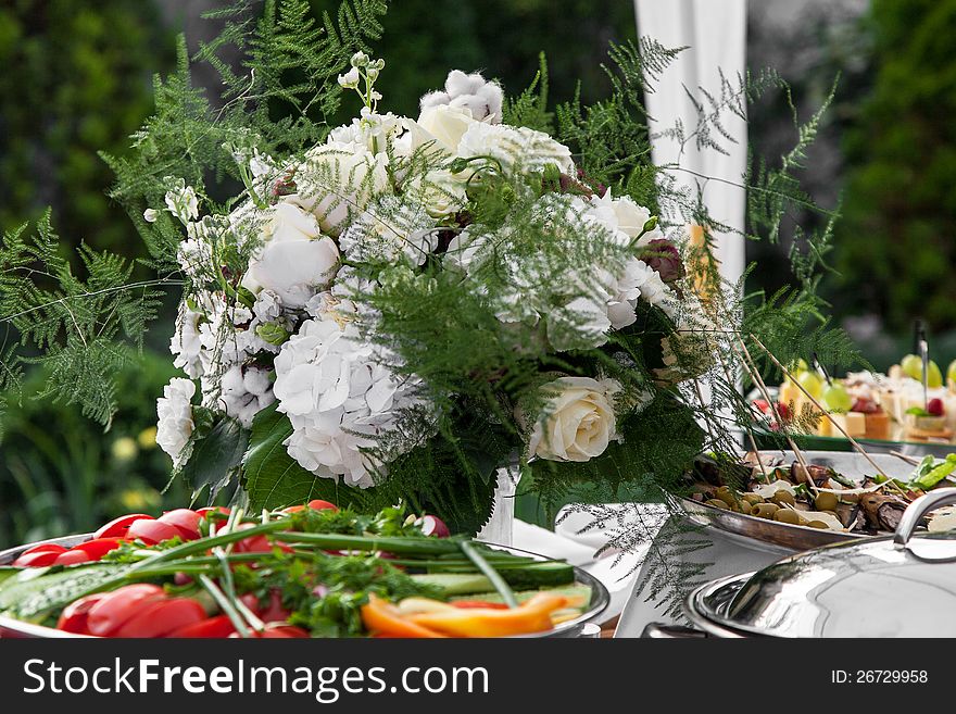 Flowers bouquet on table with snacks. Flowers bouquet on table with snacks