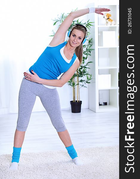 Smiling woman doing stretching exercise at the living room. Smiling woman doing stretching exercise at the living room