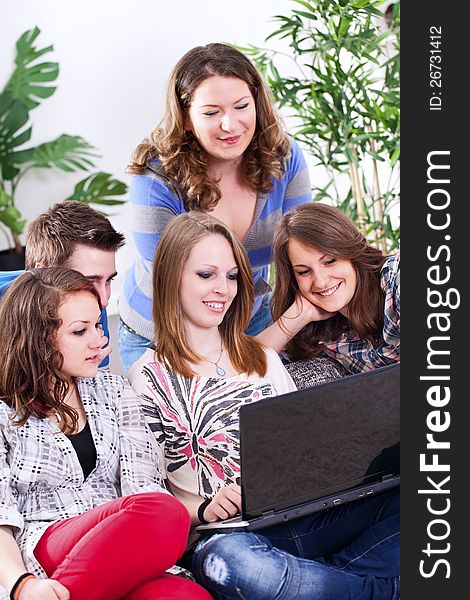 Smiling group of young people with laptop