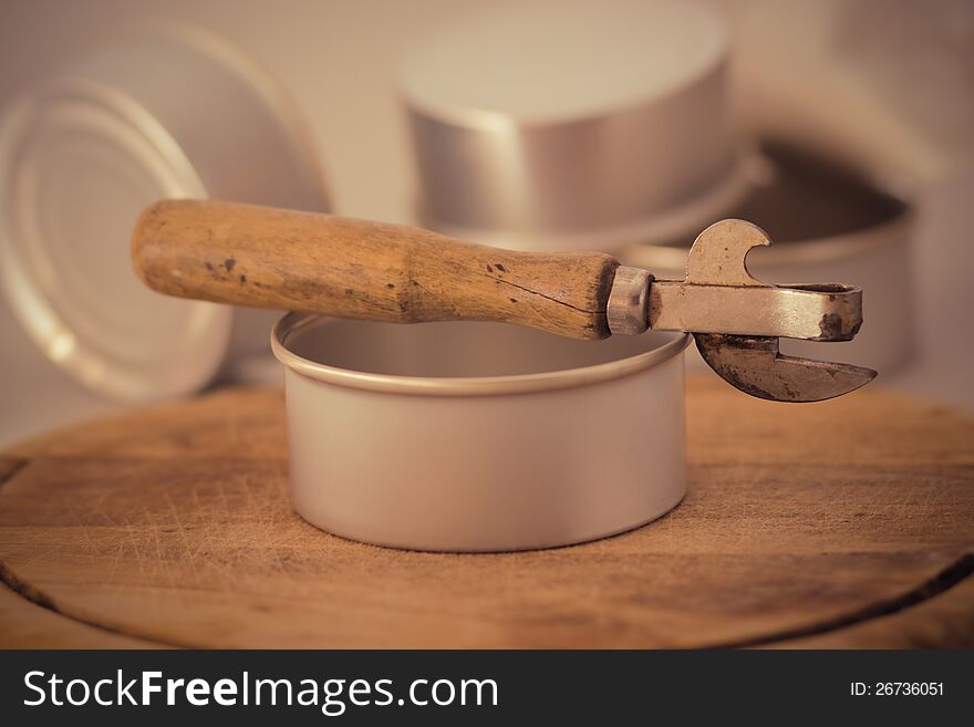 An old opener surrounded by tins. An old opener surrounded by tins