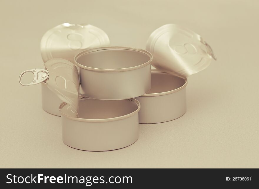 Four opened clear tincans on a neutral background